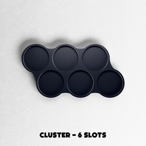 May include: A dark navy blue cluster with six circular slots. The slots are arranged in a curved pattern. The text "CLUSTER - 6 SLOTS" is printed in bold, black letters at the bottom of the image.