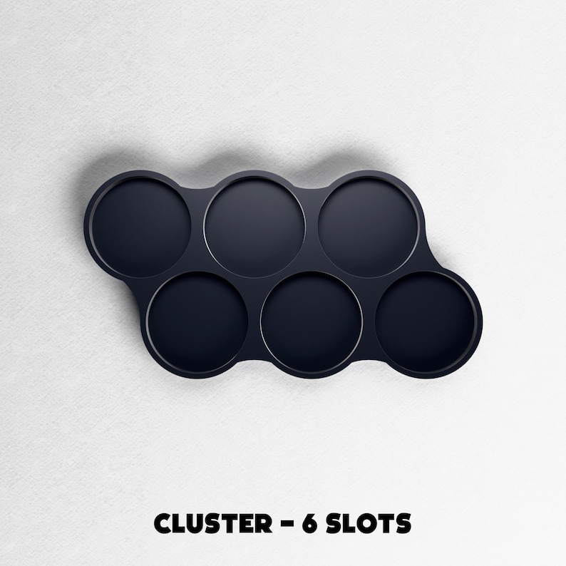 May include: A dark navy blue cluster with six circular slots. The slots are arranged in a curved pattern. The text "CLUSTER - 6 SLOTS" is printed in bold, black letters at the bottom of the image.