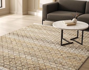May include: A rectangular area rug featuring a repeating diamond pattern in shades of tan, beige, and dark brown. The rug has a textured surface and is finished with short white fringe along the two shorter edges, lying flat on a light wood floor.