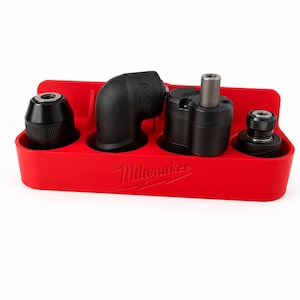 Peut inclure: Un plateau de rangement rouge en plastique Milwaukee contenant quatre accessoires d'outils électriques noirs. Le plateau porte le logo Milwaukee en relief sur le devant. Les accessoires incluent un mandrin, un renvoi d'angle et un porte-embout.