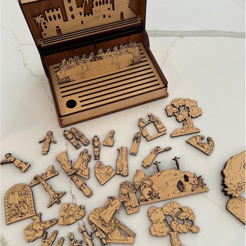 K&ouml;nnte beinhalten: Ein h&ouml;lzernes Puzzle des Letzten Abendmahls mit einer passenden Box. Die Box zeigt eine Laserszene des Letzten Abendmahls. Die Puzzleteile zeigen verschiedene biblische Szenen und Figuren, alle in nat&uuml;rlicher Holzoptik.