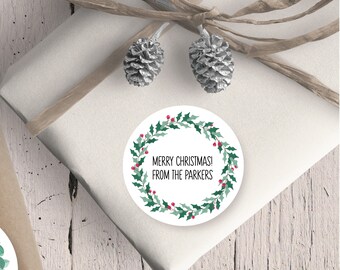 May include: Round white sticker with a green holly wreath and red berries. The text "Merry Christmas! From the Parkers" is printed in black inside the wreath.