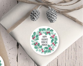 May include: Round white sticker with a green wreath of leaves and red berries. The text on the sticker reads "Happy Holidays! From the Parkers".