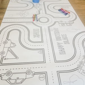 May include: A black and white colouring page featuring a road course with cars, stop signs, and the text "Happy Birthday Blake".