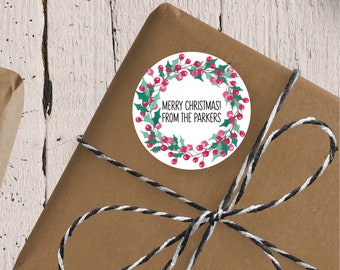 May include: A round white gift tag with a green holly wreath with red berries. The tag says "Merry Christmas! From the Parkers".