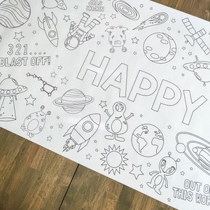 May include: A black and white coloring page with a space theme. It features a rocket, planets, stars, aliens, and the word "HAPPY". The text "321... BLAST OFF!" and "OUT OF THIS WORLD" are also included.