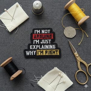May include: A black patch with the text "I'M NOT ARGUING I'M JUST EXPLAINING WHY I'M RIGHT" is surrounded by sewing notions. The image includes spools of thread, scissors, pins, a thimble, and a coin, all arranged on a grey surface.