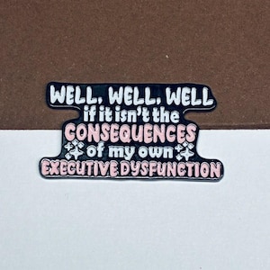 May include: A black enamel pin with a wavy, irregular shape featuring white and light pink text that reads: WELL, WELL, WELL if it isn't the CONSEQUENCES of my own EXECUTIVE DYSFUNCTION, accented with small white star-like sparkles.