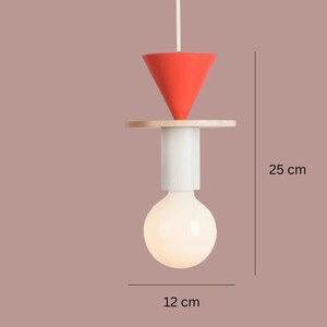 Peut inclure: Suspension luminaire moderne. Il comprend un c&ocirc;ne rouge, un disque en bois et une base cylindrique blanche, avec une grosse ampoule blanche et ronde. La lampe mesure 25 cm de haut et 12 cm de large.