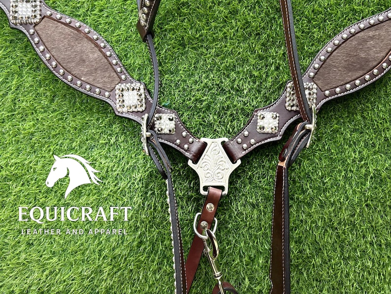 Puede incluir: Un juego de guarnicioner&iacute;a de cuero marr&oacute;n para caballos con adornos plateados. El juego incluye un petral, una brida y riendas. El petral presenta un panel central de material marr&oacute;n texturizado y tachuelas plateadas decorativas.