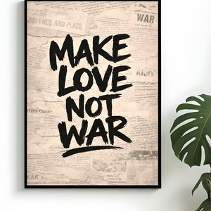 Könnte beinhalten: Gerahmter Kunstdruck mit dem Schriftzug "MAKE LOVE NOT WAR" in fetten, schwarzen Buchstaben. Der Hintergrund besteht aus alten Zeitungsausschnitten, was ihm einen Vintage-Look verleiht. Eine Zimmerpflanze ist in der Ecke zu sehen.