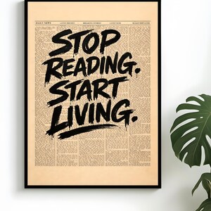 Może przedstawiać: Oprawiony wydruk z czarną obwódką. Tło to nadruk z gazety w stylu vintage. Pogrubiony czarny tekst brzmi "STOP READING. START LIVING." Wydruk jest wyświetlany na białej ścianie z zieloną rośliną w tle.