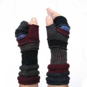 May include: A pair of fingerless gloves with a striped pattern in shades of gray, black, burgundy, and blue. The gloves are knit and have a fold-over cuff.