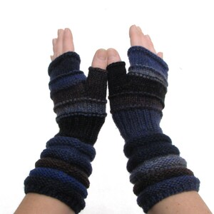 May include: A pair of fingerless gloves with a striped pattern in shades of blue and black. The gloves are knitted and have a cuff that extends up the forearm.