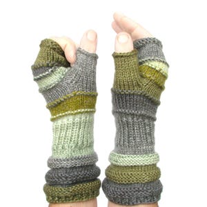May include: A pair of fingerless gloves with a striped pattern in shades of green, gray, and white. The gloves are knitted and have a cuff that folds over.