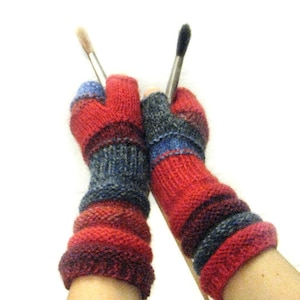May include: A pair of fingerless gloves with a red, blue, and gray striped pattern. The gloves are knitted and have a textured look.