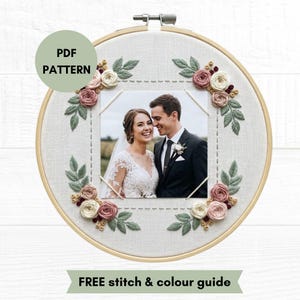 May include: A round wooden embroidery hoop framing a photograph of a couple in wedding attire. The fabric border features hand-embroidered dusty pink and cream roses with sage green leaves. Text on the image reads PDF PATTERN and FREE STITCH & COLOUR GUIDE.