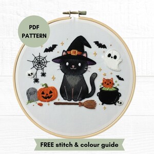 May include: An embroidery hoop containing a white fabric with a Halloween-themed design featuring a black cat in a witch hat, a ghost, an orange pumpkin, a black cauldron with an orange cat, a spider web, a tombstone, and bats. Text reads PDF PATTERN.