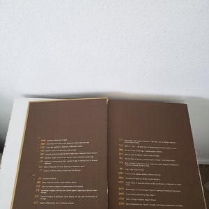 May include: A brown book with a timeline of historical events. The book has a gold spine and gold lettering. The timeline includes dates and descriptions of events from 2600 BC to 1204 AD.