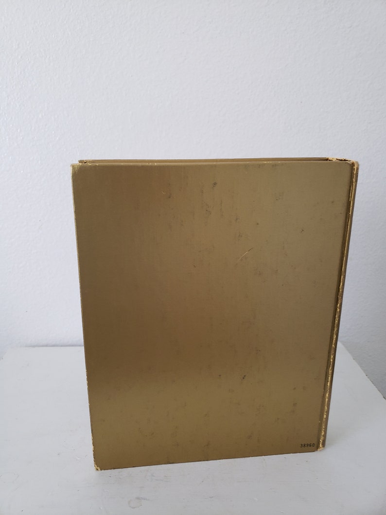 May include: A gold-colored book with a plain cover and the number 38860 printed on the bottom right corner.