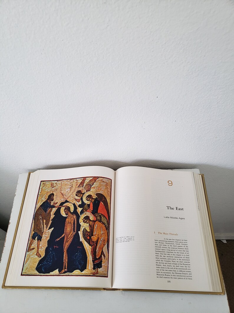 May include: An open book with a colorful illustration of a religious scene. The book is titled "The East" and the page number is 9. The text on the page discusses the "Main Threads" of the Late Middle Ages.