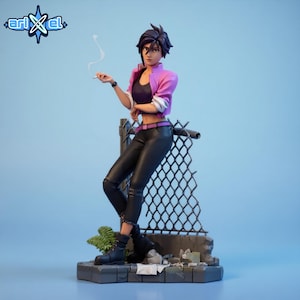 May include: A figurine of a person in a pink jacket, black top, and black pants, leaning against a chain-link fence. The figure is holding a cigarette. The base is a concrete-like structure with some greenery and debris. The Arikel logo is in the upper left corner.