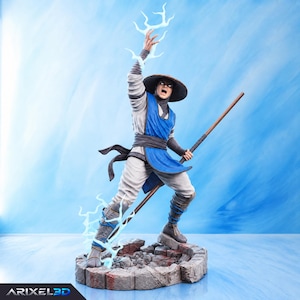 Puede incluir: Una figura detallada de un guerrero con un atuendo azul y blanco y un sombrero de ala ancha, sosteniendo un bastón de madera. La figura se alza sobre una base de piedra, con una mano levantada emitiendo rayos azules y el texto ARIXEL3D visible.