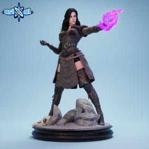 May include: A detailed figurine of a woman in a dark outfit, holding a glowing purple energy ball. The figure stands on a rocky base with a skull, with the "ariXel" logo in the upper left corner. The woman is wearing a dark outfit with a belt and boots.