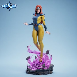 May include: A figurine of a female superhero in a yellow and blue costume with red hair. The figure is standing on a purple energy base. The Arikel logo is in the upper left corner.