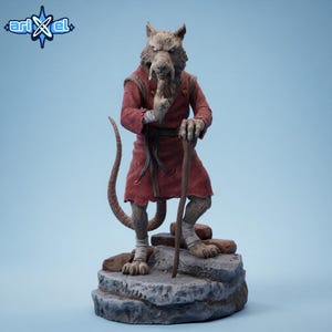 May include: A detailed figurine of a rat-like character in a red robe, holding a wooden staff. The figure stands on a stone base, with a long tail and wrapped feet. The figure has a stern expression. The logo "ari x el" is in the top left corner.