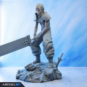 May include: A monochromatic gray figurine of a spiky-haired character standing on a rocky base. The figure wears shoulder armor and loose trousers, holding a large, flat, rectangular sword. A smaller sword is stuck in the base near the feet.