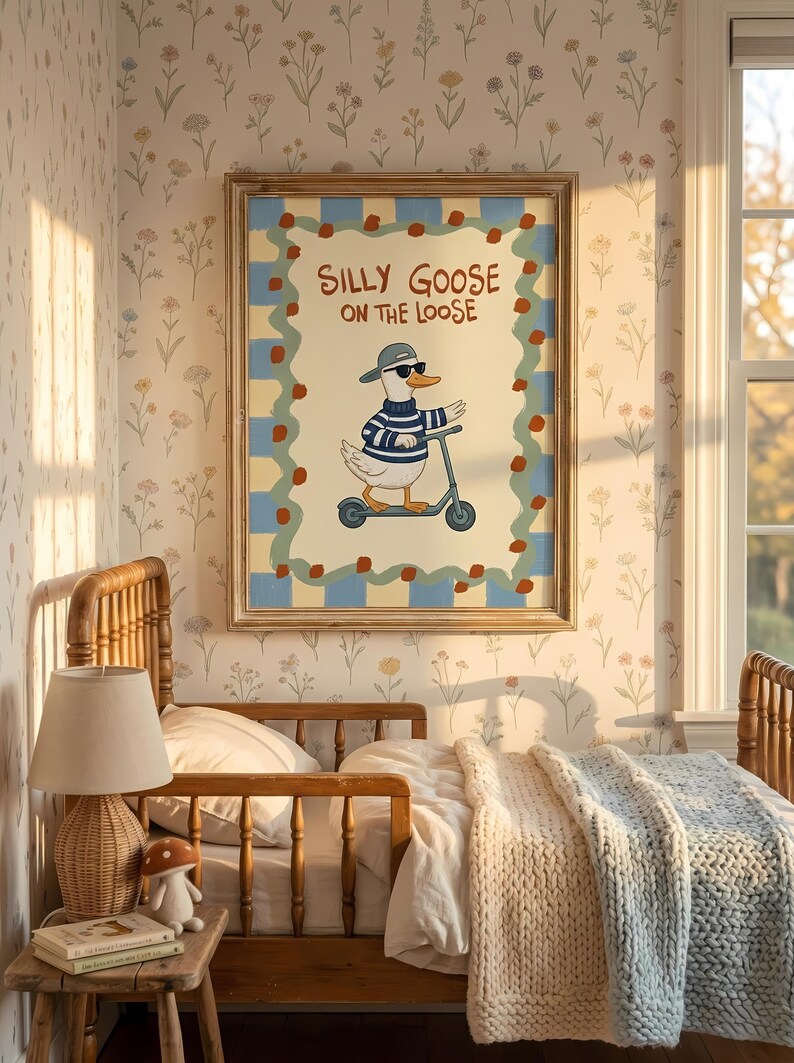 a cozy bedroom scene with a framed poster of a cartoon goose riding a scooter on the wall. The poster has a playful and whimsical design, adding a touch of fun to the room. The bed is neatly made, and there are some books and a lamp on the bedside table, creating a comfortable and inviting atmosphere.