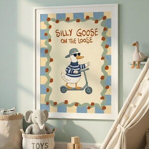 a framed poster of a cartoon goose riding a scooter, surrounded by a checkered border and a playful design. The poster is displayed on a wall in a child's bedroom, with a beige tent and a basket of toys nearby.