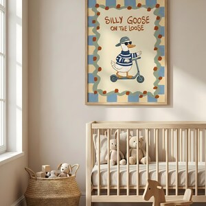 A nursery room with a crib, a rocking horse, and a basket filled with toys. Above the crib is a framed poster of a cartoon goose riding a scooter, with the text "Silly Goose on the Loose" written on it.