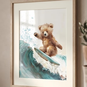 Puede incluir: Impresión en acuarela enmarcada de un oso de peluche marrón surfeando una ola. El oso está sobre una tabla de surf azul claro, montando una ola turquesa con espuma blanca. El marco es de madera clara.