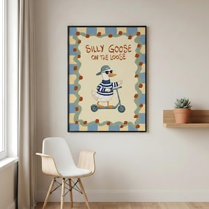 a poster of a cartoon goose riding a scooter, with the text "Silly Goose on the Loose" written on it. The poster is hanging on a wall, and there is a chair and a potted plant in the foreground.
