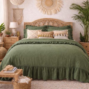 Può includere: Una camera da letto con un copriletto verde e cuscini decorativi. Il letto ha una testiera intrecciata. Un lampadario e un arazzo a parete intrecciati si aggiungono allo stile bohémien. Una pianta in vaso completa l'arredamento.