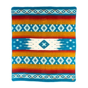 Puede incluir: Una manta estampada turquesa, roja y dorada. La manta presenta diseños geométricos de diamantes y rayas. El diseño central es un rectángulo blanco con un patrón de diamantes turquesa. La manta es rectangular.