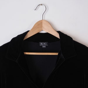 K&ouml;nnte beinhalten: Schwarzes Samt-Langarmhemd mit Kragen und einem BCBG Max Azria-Etikett. Hergestellt in den USA.