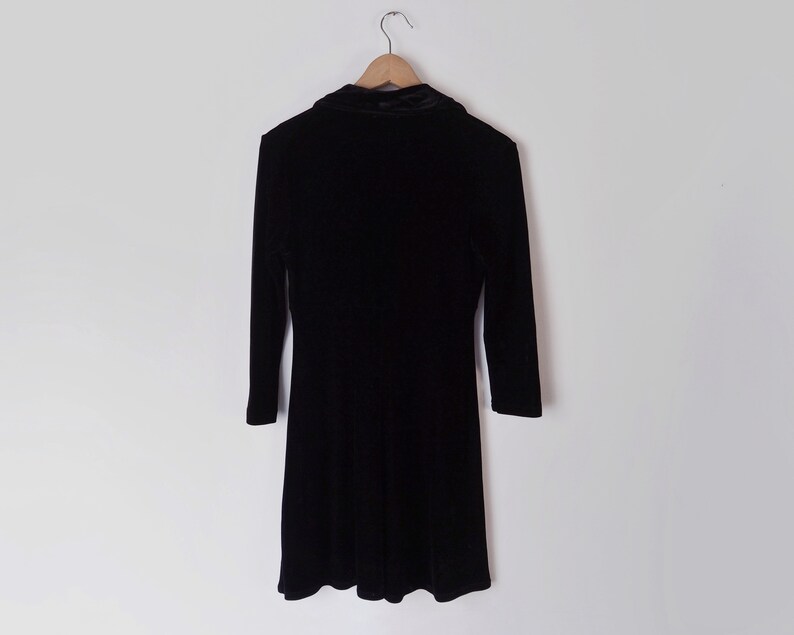 K&ouml;nnte beinhalten: Ein schwarzes Samtkleid mit Stehkragen und 3/4 &Auml;rmeln.
