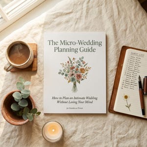 Pode incluir: Um livro branco intitulado The Micro-Wedding Planning Guide com uma ilustração de um buquê de flores, o subtítulo How to Plan an Intimate Wedding Without Losing Your Mind e o texto 50 Guests or Fewer, sobre um tecido texturizado.