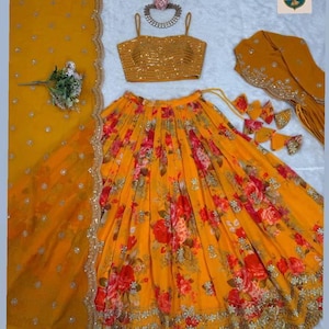 May include: A mustard yellow lehenga choli set featuring a sleeveless blouse with horizontal sequin stripes, a flared skirt with a vibrant red and orange floral print, and a matching dupatta with scalloped gold embroidered borders and small sequins.