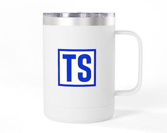 Può includere: Una tazza da viaggio in acciaio inossidabile bianco con manico e coperchio trasparente. Il centro della tazza presenta un contorno quadrato blu contenente le lettere maiuscole blu TS. La tazza ha una finitura opaca liscia e una forma cilindrica.