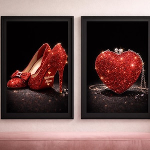 May include: Two framed art prints. One features a pair of red glitter high heels with a bow and the words "Welcome Home". The other print shows a red glitter heart-shaped purse with a chain strap. Both are set against a black background.