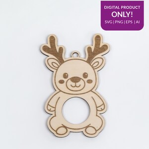 Puede incluir: Adorno de reno de madera con una abertura circular en el centro. El reno tiene cuernos detallados, una cara sonriente y un peque&ntilde;o agujero para colgar. El texto "DIGITAL PRODUCT ONLY!" est&aacute; en la esquina superior derecha.
