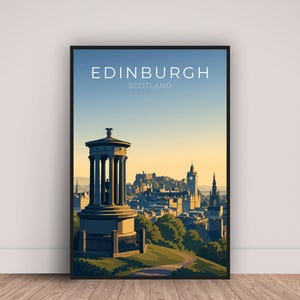 May include: A framed art print featuring a stylized illustration of Edinburgh, Scotland. The artwork depicts a monument with columns, a cityscape, and the text "EDINBURGH SCOTLAND" against a gradient blue and yellow sky. The print is displayed on a wooden floor.