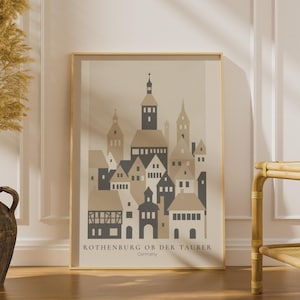 Könnte beinhalten: Ein gerahmter Wandkunstdruck mit einer stilisierten grafischen Illustration der Stadt Rothenburg ob der Tauber, Deutschland. Das Kunstwerk verwendet eine neutrale Farbpalette aus Beige, Hellbraun und Dunkelgrau, um Gebäude und Türme darzustellen.