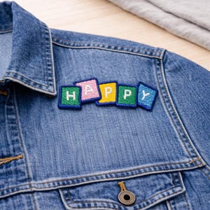 May include: A white ceramic mug with a black handle and the text "But First, Coffee" in a black, handwritten-style font. The mug is on a white surface.