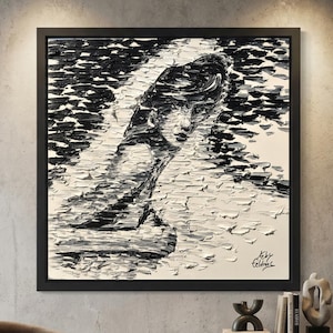 Puede incluir: Una gran pintura abstracta en blanco y negro enmarcada de la cara y la parte superior del cuerpo de una mujer. La obra de arte se exhibe sobre un mueble de madera oscura y un sill&oacute;n curvo marr&oacute;n. La habitaci&oacute;n tiene un dise&ntilde;o moderno y minimalista.