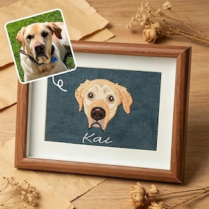 Puede incluir: Retrato bordado enmarcado de un perro Labrador Retriever amarillo con el nombre "Kai" bordado debajo. El marco es de color madera, y una foto más pequeña del perro está en la esquina superior izquierda. El fondo es azul verdoso.